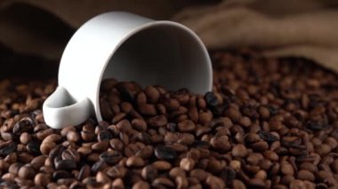 kavrulmuş kahve çekirdekleri beyaz kupa dökülen