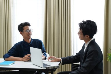 İki iş adamı görüşüyor, tartışıyorlar ve çalışma masasında bir anlaşma yapıyorlar.