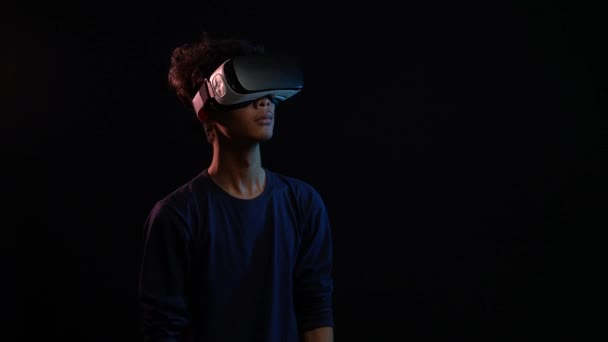 男人用虚拟现实耳机在黑色上玩隔离游戏 — 图库视频影像