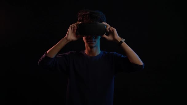 Νεαρός Άνδρας Που Χρησιμοποιεί Ακουστικά Εικονικής Πραγματικότητας Απομονωμένα Μαύρο Φόντο — Αρχείο Βίντεο