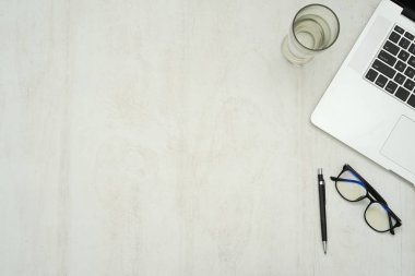Dizüstü bilgisayarı, akıllı telefonu ve malzemeleri olan ahşap çalışma masası..