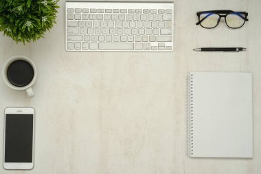 Dizüstü bilgisayarı, akıllı telefonu ve malzemeleri olan ahşap çalışma masası..