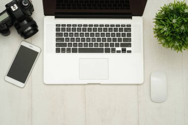 Kameralı ahşap masa masası, lens, laptop, akıllı telefon ve malzeme. Üst manzara, düz uzanma