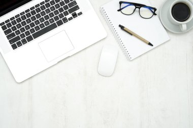 Dizüstü bilgisayarı, akıllı telefonu ve malzemeleri olan ahşap çalışma masası..