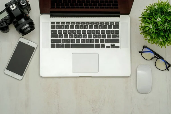 Kameralı ahşap masa masası, lens, laptop, akıllı telefon ve malzeme. Üst manzara, düz uzanma