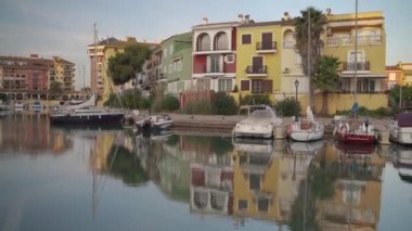 Port saplaya 'daki huzurlu nehir manzarası renkli evler ve nehir kıyısında park etmiş tekneler.