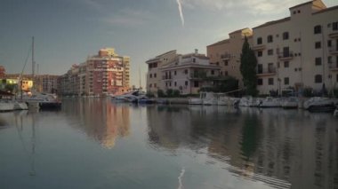 Port saplaya 'daki huzurlu nehir manzarası renkli evler ve nehir kıyısında park etmiş tekneler.