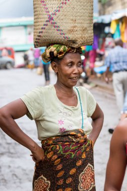 Nosy Be, Madagaskar-17 Ocak, 2019: yerel bir Madagaskar kadını, Nosy Be, Madagaskar 'da kafasına meyve ile bir sepet tutan ve taşıyan gıda seeling.