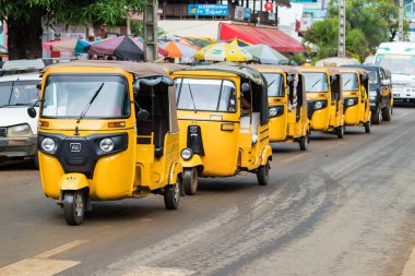 Nosy Be, Madagaskar-17 Ocak, 2019: bir satırda sarı tuk-Tuks hattı, Nosy Be, Madagaskar bir taksi motorlu üç tekerlekli bisiklet.