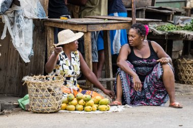Toliara, Madagaskar-Ocak 10th, 2019: Iki Malagasy kadın sokak satıcıları Toliara, Madagaskar yerel gıda pazarında kaldırım üzerinde oturan tartışmak.