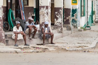 Toliara, Madagaskar-10 Ocak, 2019: üç inşaat Madagaskar işçiler Toliara, Madagaskar merkezinin bir köşesinde bir mola alarak.