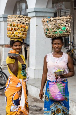 Toliara, Madagaskar-10 Ocak, 2019: Toliara, Madagaskar pazarında sokaklarda meyve satan kafalarına sepetleri ile Iki yerel Madagaskar kadın.