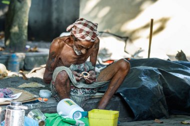 Galle, Sri Lanka-18 Şubat, 2019: bir türban giyen bir üst düzey evsiz Sri Lanka adam portresi Galle, Sri Lanka sokakta oturan çöp bir parça bakıyor.