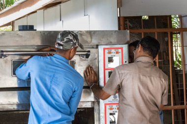 Praslin, Seyşeller-5 Şubat, 2019: Praslin, Seyşeller bir elektrikli fırın kapısını sabitleme Iki tamirci.