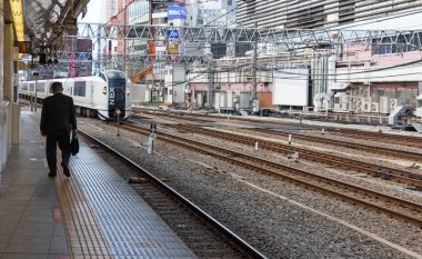 Tren platformunda yürüyen bir adam.