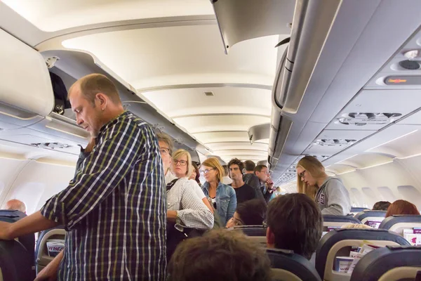 Passagers debout pour débarquer d'un avion . — Photo