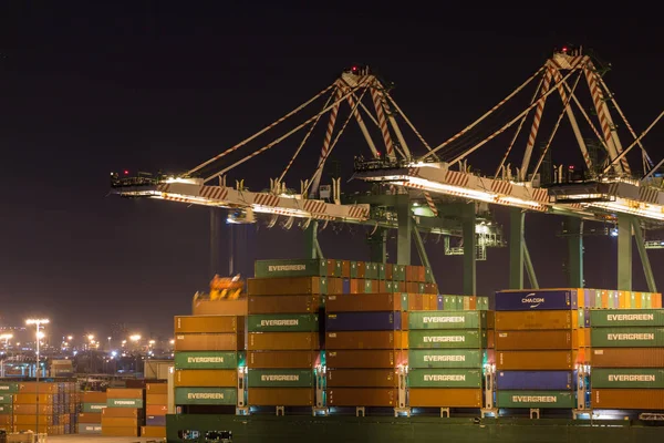 Guindastes portuários fazendo trabalho de carga à noite . — Fotografia de Stock