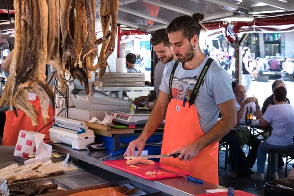 Un trabajador rebanando pescado fresco de Salomón en el famoso mercado de pescado de Bergen . — Foto de Stock