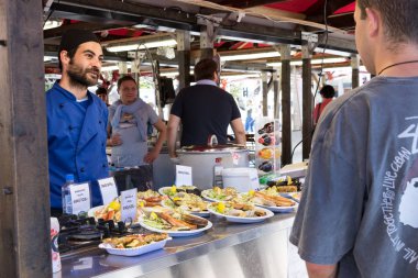 Bergen, Norveç-26 Temmuz, 2018: Bergen Fishmarket, Norveç 'te kızarmış balık gıda satan bir erkek aşçı.