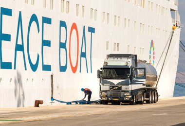 Bir Volvo kamyon Sarnıcı liman veya Corfu rıhtılmış bir Cruise Ship yakıt.