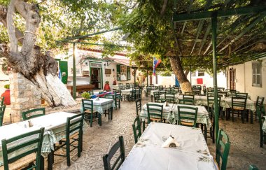 Ahşap yeşil sandalyeli geleneksel bir Yunan tavernası.