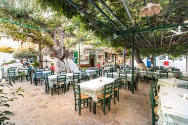 Ahşap yeşil sandalyeli geleneksel bir Yunan tavernası.