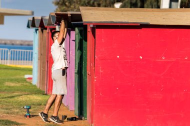 Bir erkek işçi-marangoz kontrplak kabin çatı montajı. 
