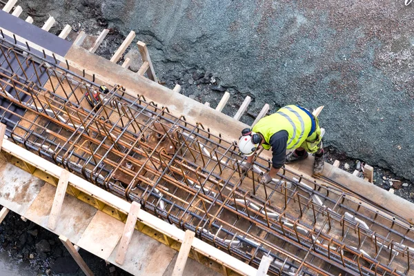 Vue de dessus d'un ouvrier du bâtiment travaillant sur une construction en béton . — Photo