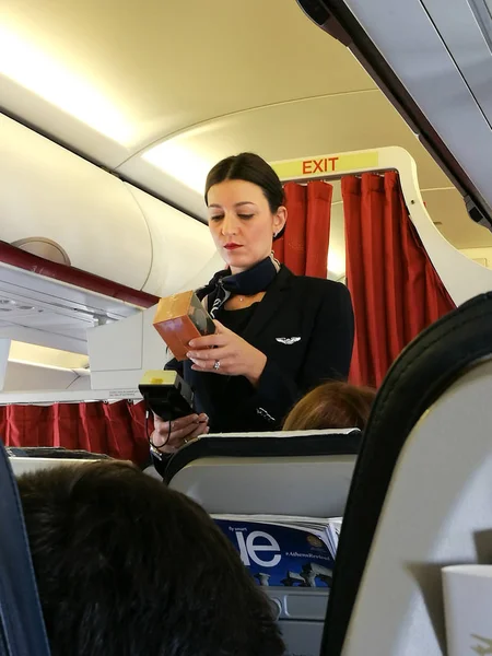 Eine Flugbegleiterin beim Auschecken eines gerade von einem Passagier gekauften Artikels. — Stockfoto