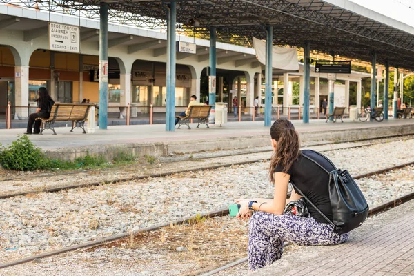 En kvinna som sitter på plattformen i Larissa Train Station. — Stockfoto