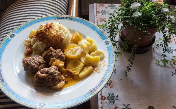 Potatoes, meat balls and rice.