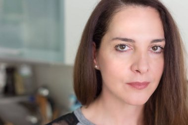 Ciddi görünümlü olgun bir kadının portresi.