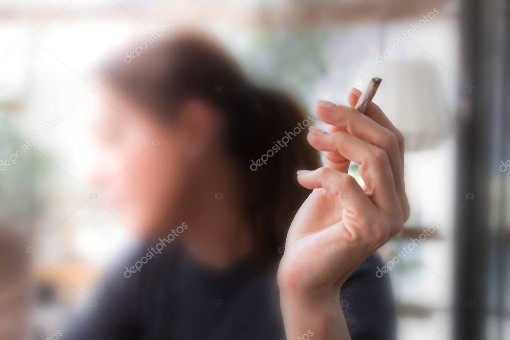 Female hand holding a cigarette