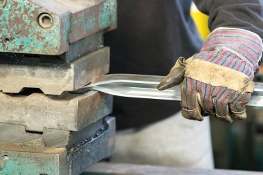 Güvenlik eldivenleri kullanan bir adam makine operatörü alüminyum ulürek.