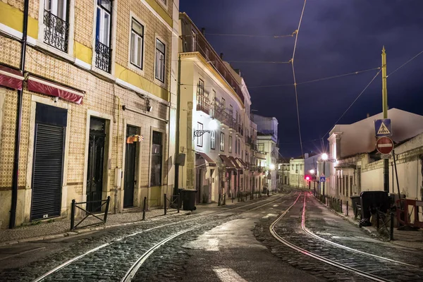 En tom gata på natten med stenbeläggning i Lissabon. — Stockfoto