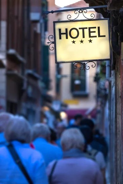 Hotel signboard iluminated on a narrow street in Venice, Italy