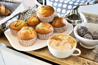 Kekler ile kapuçino bir fincan.