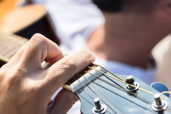 Close up of the left hand of a guitarist playing chords. 