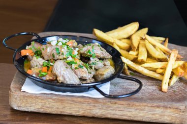 Et ve patates kızartması ile bir tava.