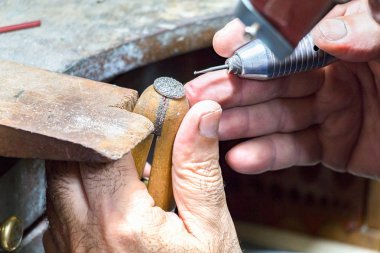 Kuyumcu bir yüzük üzerinde elmas oyma.