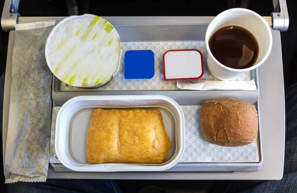 A breackfast meal on a tray in the economy class cabin of an air — Stock Photo, Image