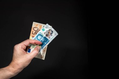 Beş pound ve 50 (elli) Euro banknotlar tutan bir erkek el, brexit kavramı, siyah üzerinde izole.
