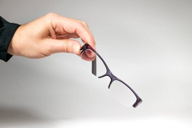 Yarım çerçevegözlük tutan bir erkek el beyaz üzerinde izole.