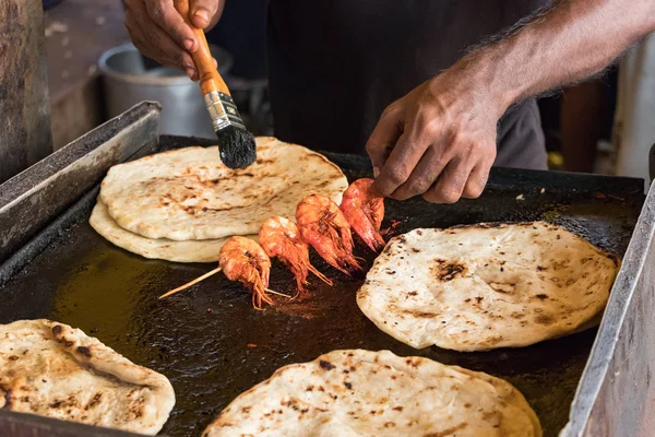 Bir aşçı Erkek el, pol roti düz ekmek tn Colombo, Sri Lanka Galle Face Dr st gıda sokak pazarı ile karides pişirme.