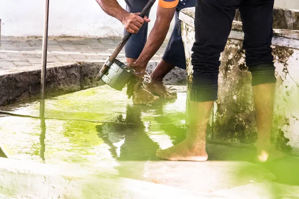 Men washing their feet making ablution on a fount in a mosque in Male,  Maldives.