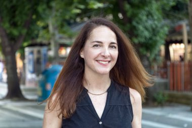 Olgun bir kadının portresi, 40s, gülümseyen görünümlü kamera açık havada.