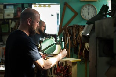 H.i eski bir perçin pres makinesi ile perçinleme bir erkek ayakkabıcı