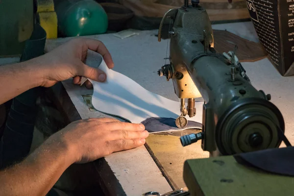 Um sapateiro masculino mãos, costura de couro com um machin de costura velho — Fotografia de Stock