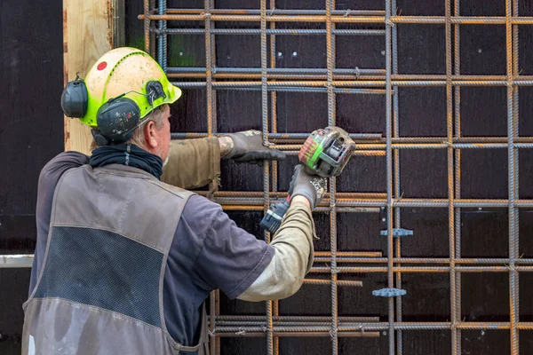 Byggnadsarbetare bockning - ledningar betong stål barer med en maskin, utomhus i Nuuk. — Stockfoto