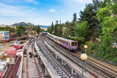 Atina 'daki Thissio İstasyonu' nun yanındaki demiryollarında çalışan Yunan alt şehir treninin perspektifi.